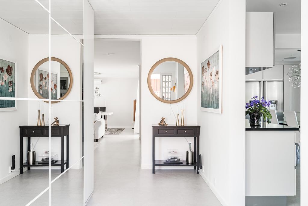 Välkomnande entréhall med god förvaring bakom spegeldörrar