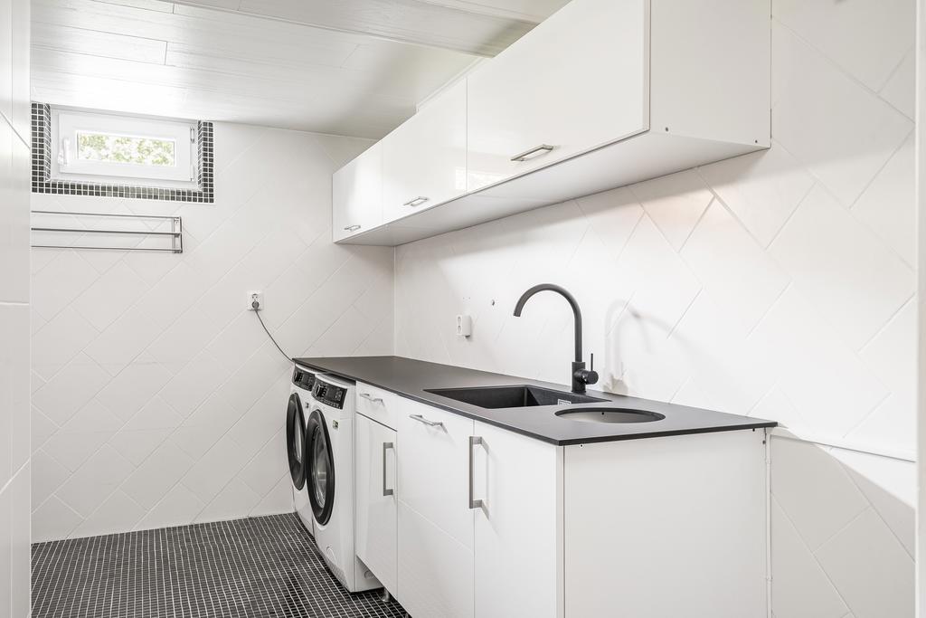 Rymlig tvättstuga med bra förvaring samt arbetsytor och tvättmaskin samt torktumlare från Electrolux
