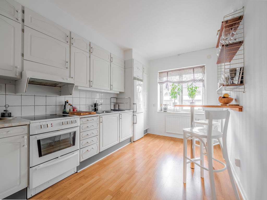 Vitt kök med plats för matbord