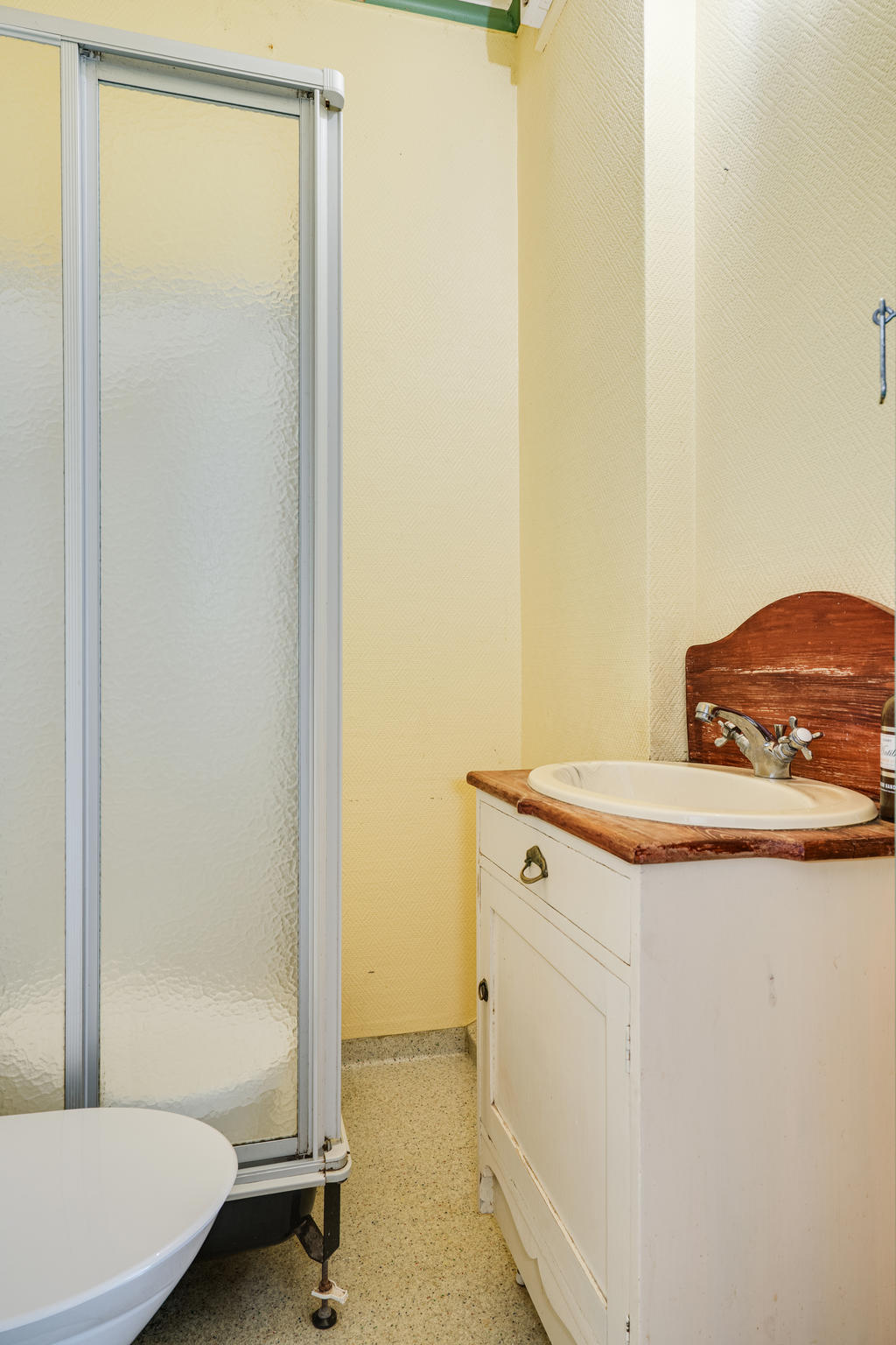 Badrum med WC, duschkabin och tvättställ.