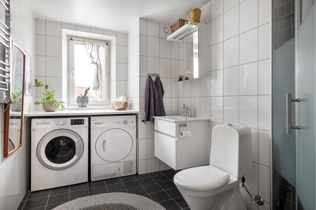 Rymligt badrum med dusch, förvaringskommod, spegelskåp och handukstork. Tvätt avdelningen med praktisk bänkskiva gör denna plats till en bra arbetsyta.