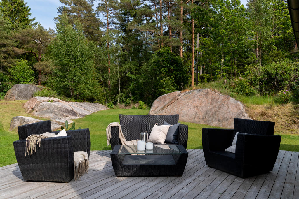 Den stora altanen på baksidan av huset bjuder in till härliga grillkvällar och mysiga stunder. Här finns plats för båda soffgrupp och matbord för flera gäster. 