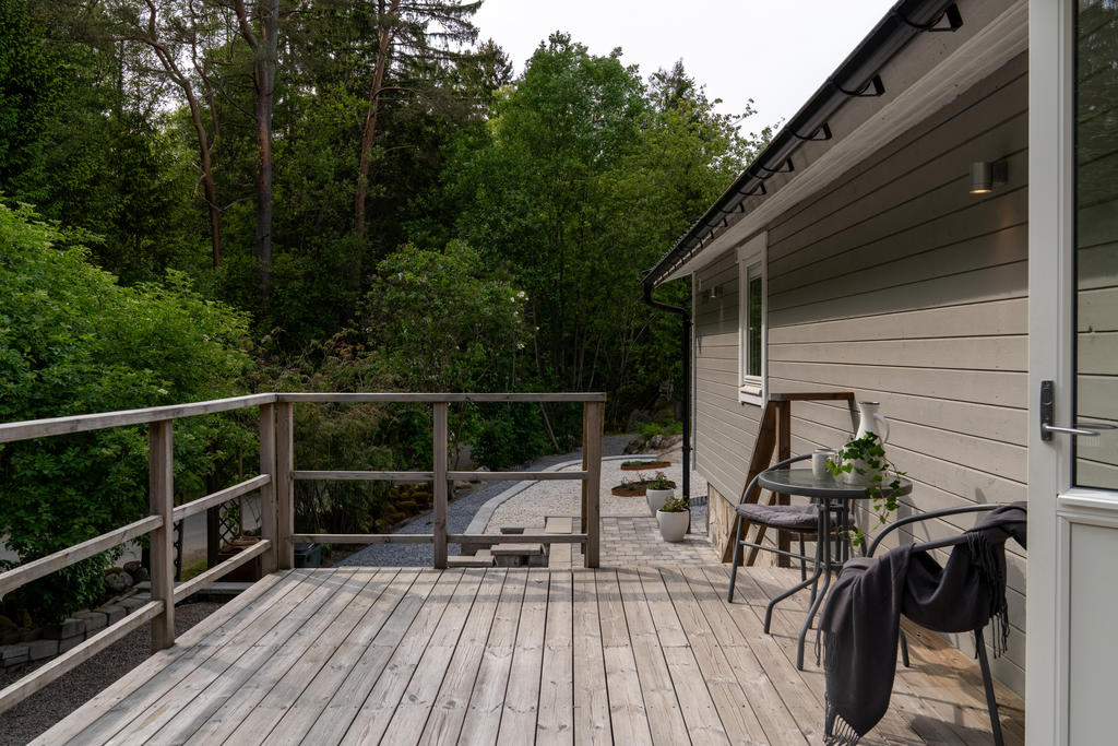 Framsidan av huset med en mysig altan i direkt anslutning till ingången i köket. 