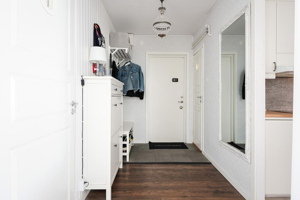 Hall med gott om plats för avhängning. Laminatgolv samt tapetserade väggar. 