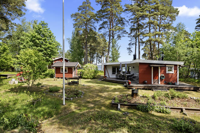 Trädgården med de 4 byggnaderna. Havet kikar fram i bakgrunden