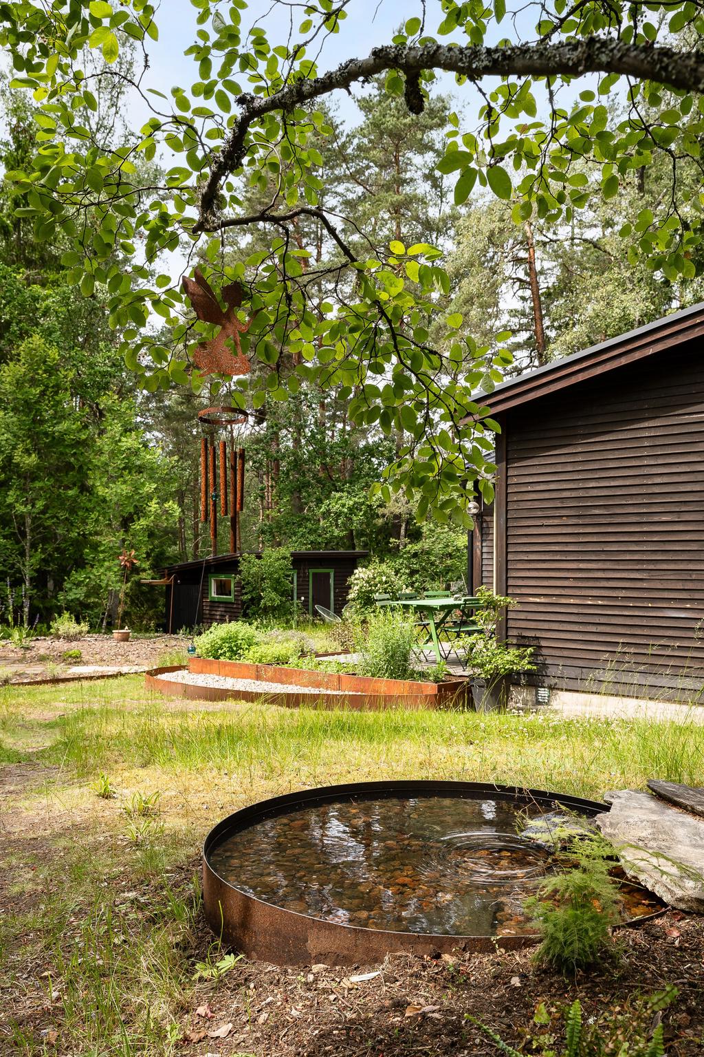 Del av trädgården med vy mot bostaden och kontorsbyggnaden