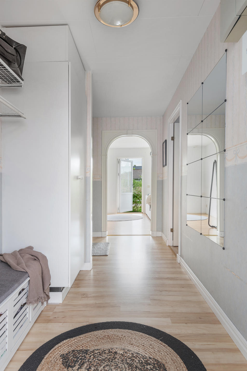 Välkomnande hall med avhägningsyta och förvaring i inbyggda garderober