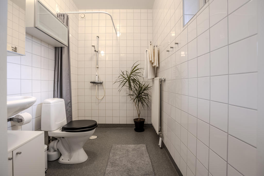 Rymligt badrum med kakel på väggarna