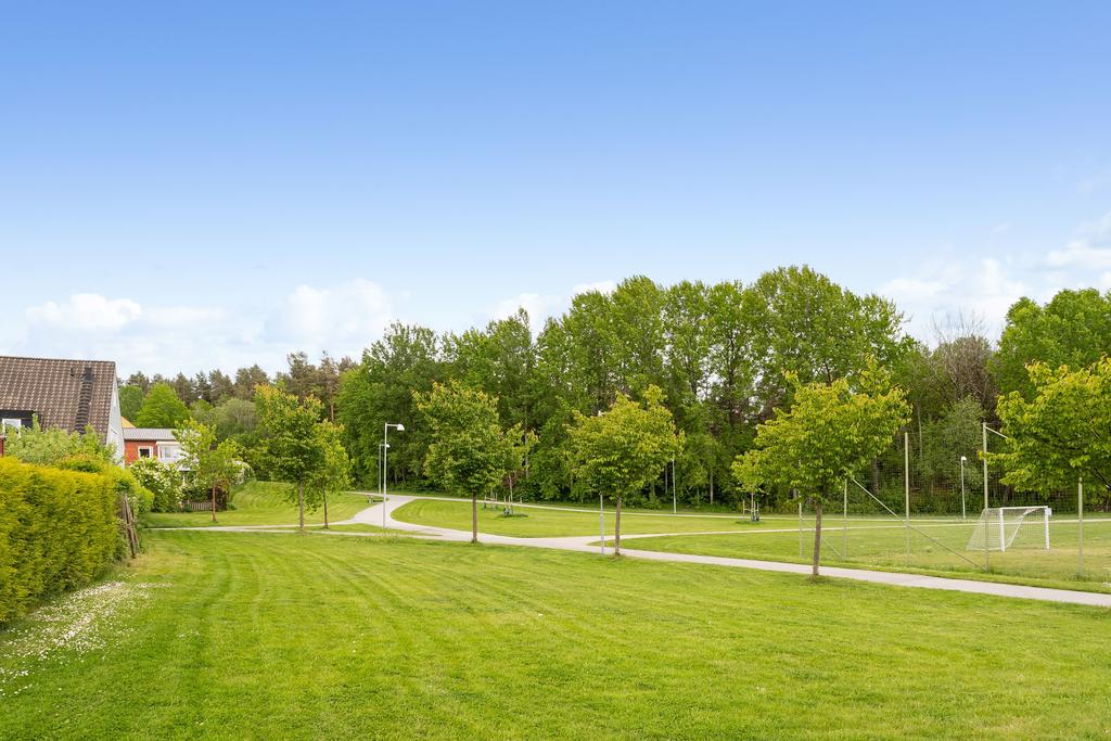 Öppna grönytor, lekplats och fotbollsplan bakom radhuset
