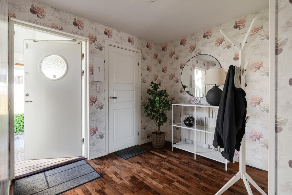 Denna rymliga och välkomnande hall kombinerar funktionalitet med stil för att skapa en harmonisk entré till hemmet.