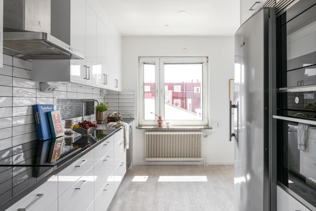 Renoverat kök med bland annat vinkyl och bänkskiva i svart granit