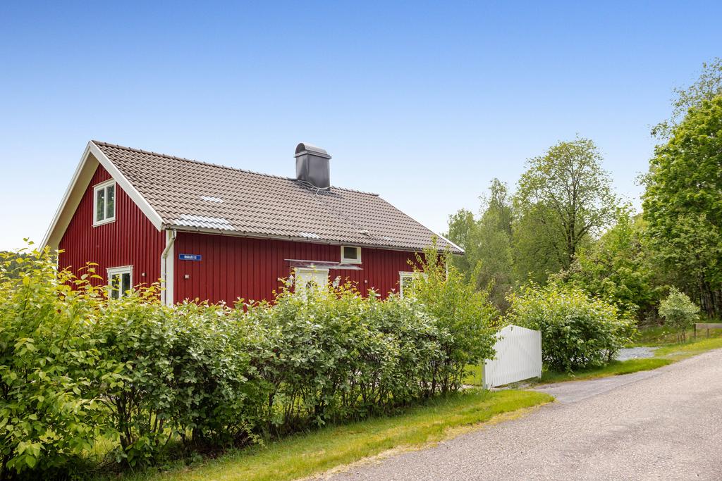 Tomten omgärdas av en grön häck.
