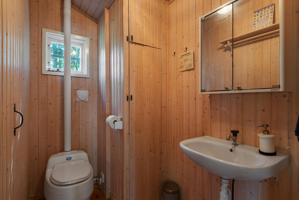 Separett och handfat inne i huset. Sommartid finns en utedusch på tomten.