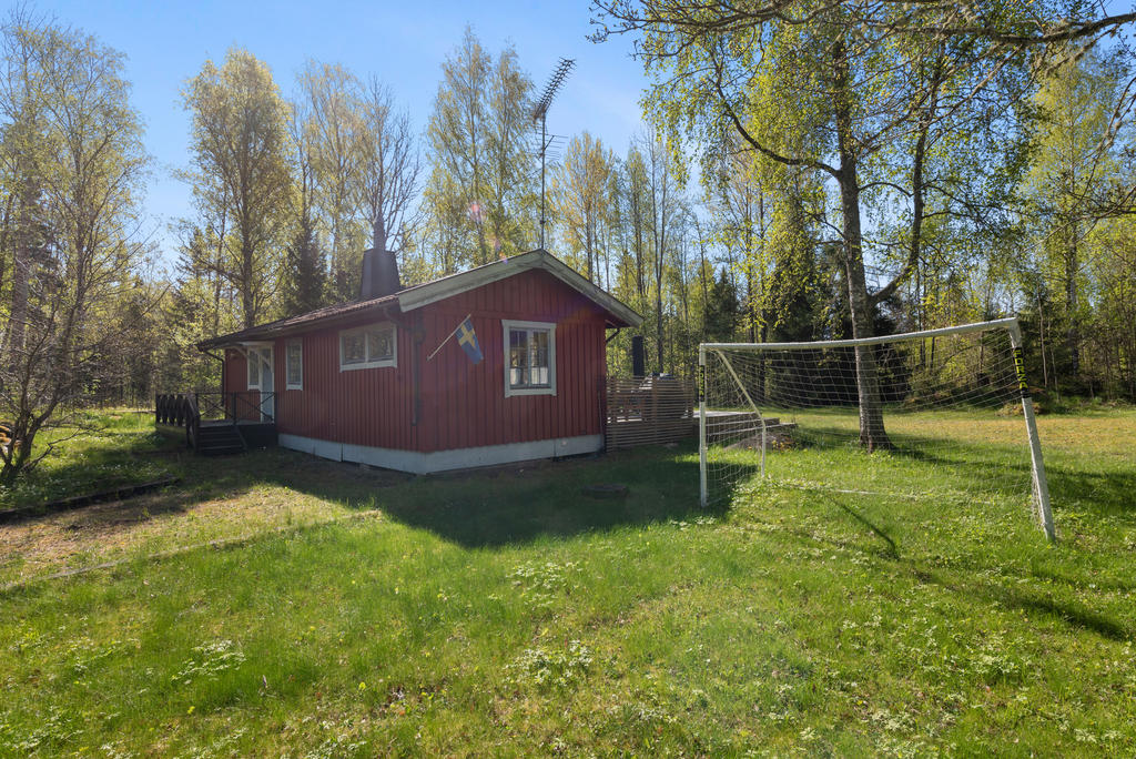 Framsidan på huset. Solig tomt med plats för lek och spring.