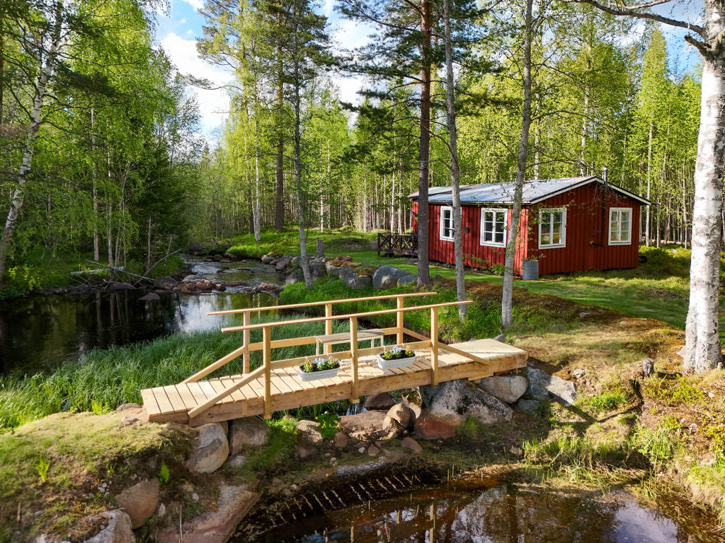 Bäckstugan med en nybyggd bro som går över bäcken. 
