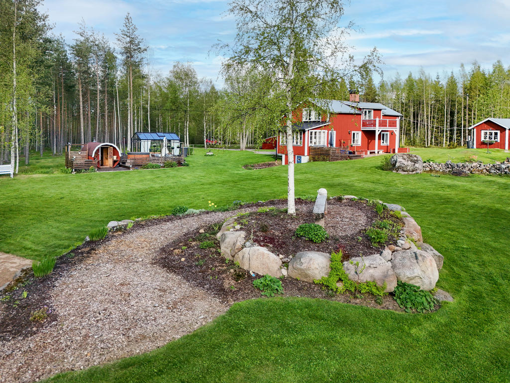 Vy över den anlagda trädgården och uteplatsen "snigeln" som byggts upp av stenar från tomten. 