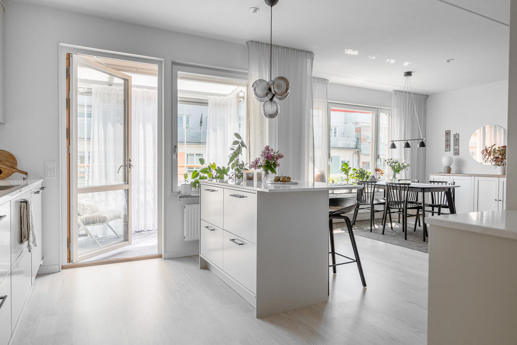 Kök med öppen planlösning mot matplats och vardagsrum.