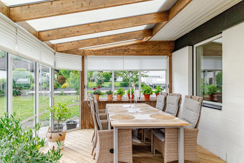 Uterum med trägolv och stora glaspartier – en plats för lugna stunder och trevliga middagar året om