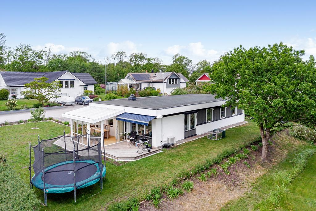 Tomten omges av träd och öppna vyer på fram och baksidan av huset 