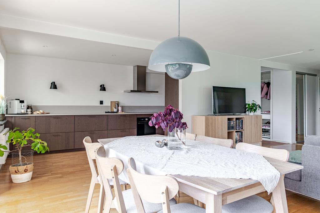 Den öppna planlösningen mellan kök, matplats och vardagsrum skapar en sammanhängande och funktionell yta med goda möjligheter för både vardagsliv och umgänge