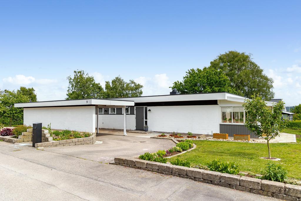 Lugnt villaområde med grönska och öppna ytor omkring husen