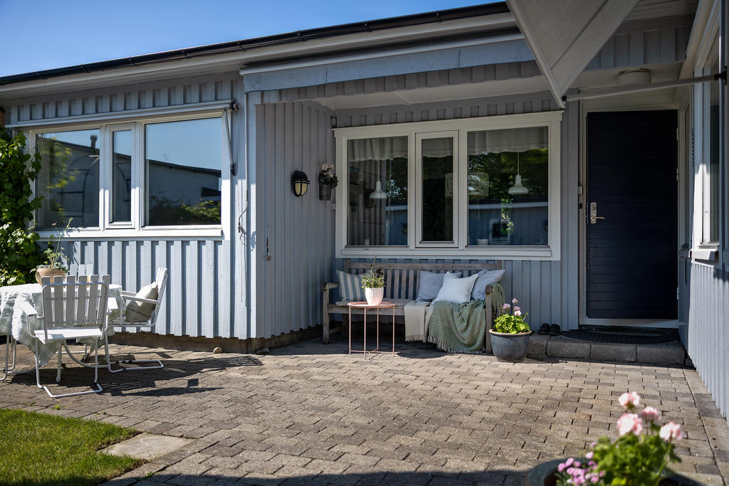 Solig insynsskyddad atriumgård med plats för flera sittgrupper