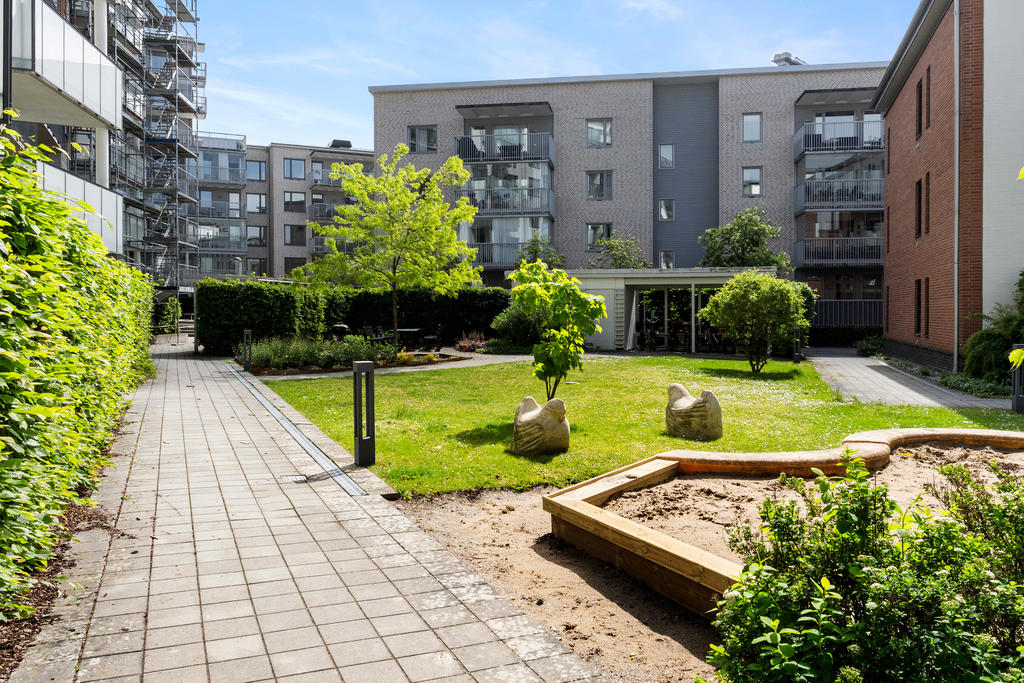 Den grönskande, skyddade innergården med grillplats.