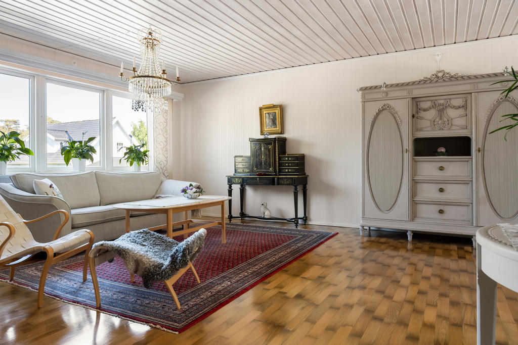 Vardagsrummet på övre plan erbjuder en idealisk sällskapsyta med en öppen planlösning mot matsalsplatsen, vilket skapar en inbjudande och funktionell atmosfär för både avkoppling och umgänge.