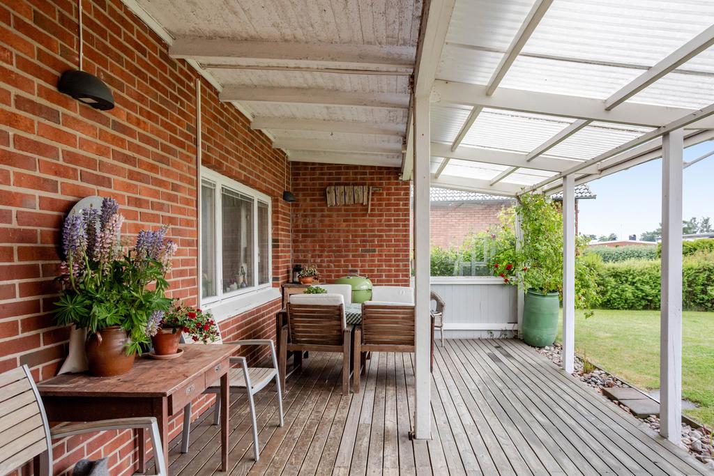 På husets framsida finns en mysig uteplats under tak i bästa söderläge
