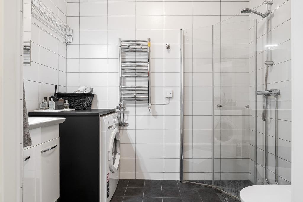 Helkaklat badrum utrustat med tvättmaskin för extra bekvämlighet