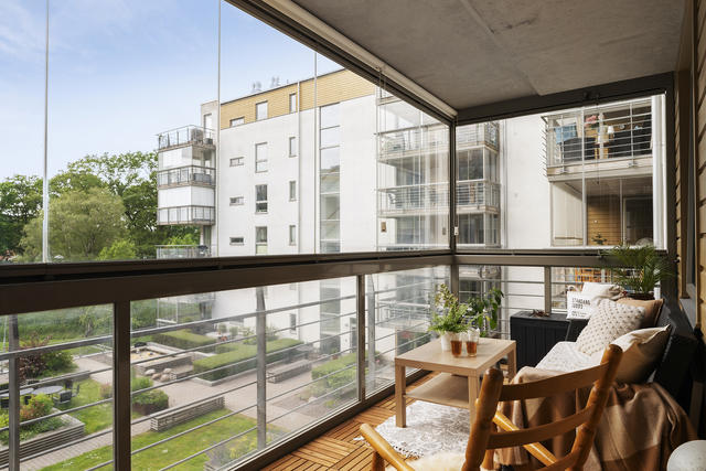 Stor inglasad balkong med plats för lounge grupp ett extra rum att njuta av året runt.
