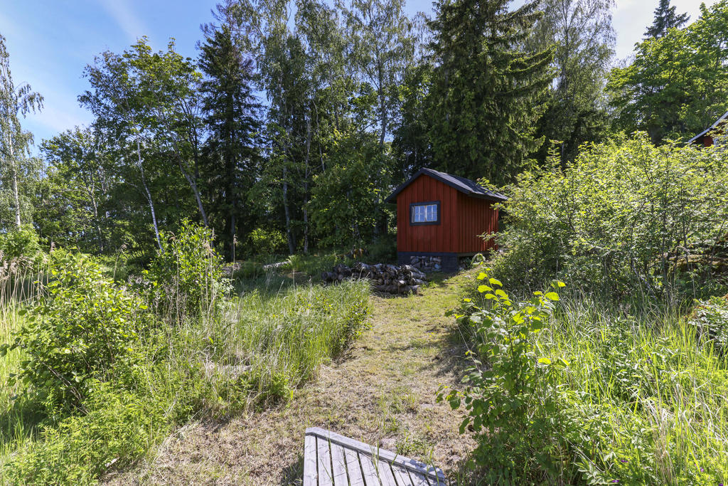 Gång från bryggan upp mot huset samt redskapsbod. 