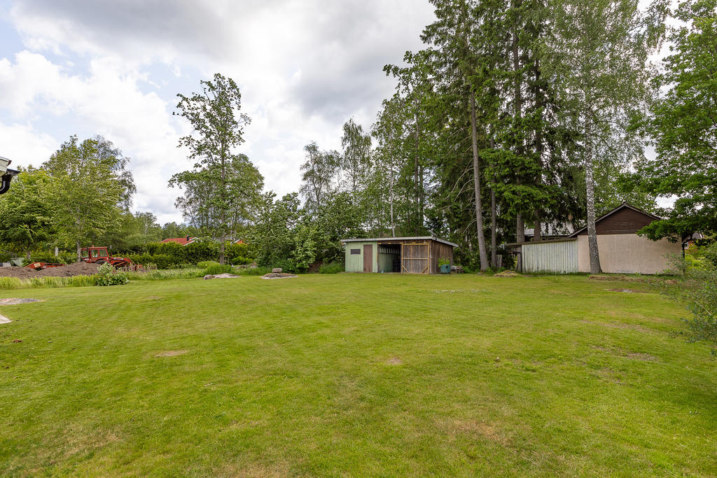 Stor trädgård med uthusbyggnad/vedbod
