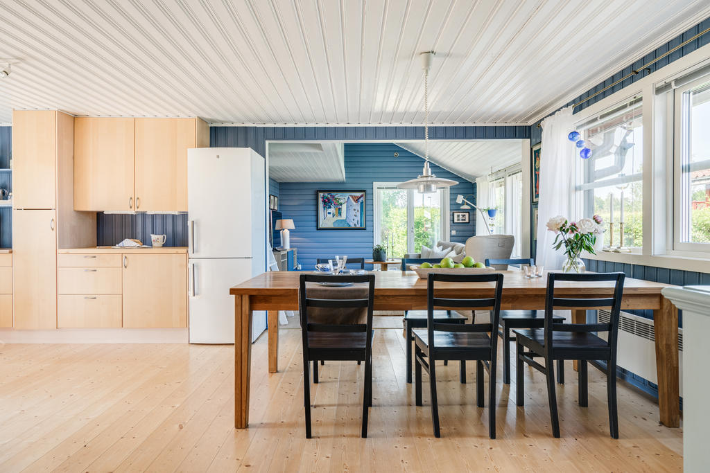 Kök och vardagsrum i ljus och öppen planlösning.-Gediget trägolv och loft med sovplatser.