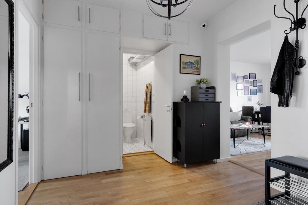 Rymlig hall med förvaringsmöjligheter i inbyggda garderober och överskåp 
