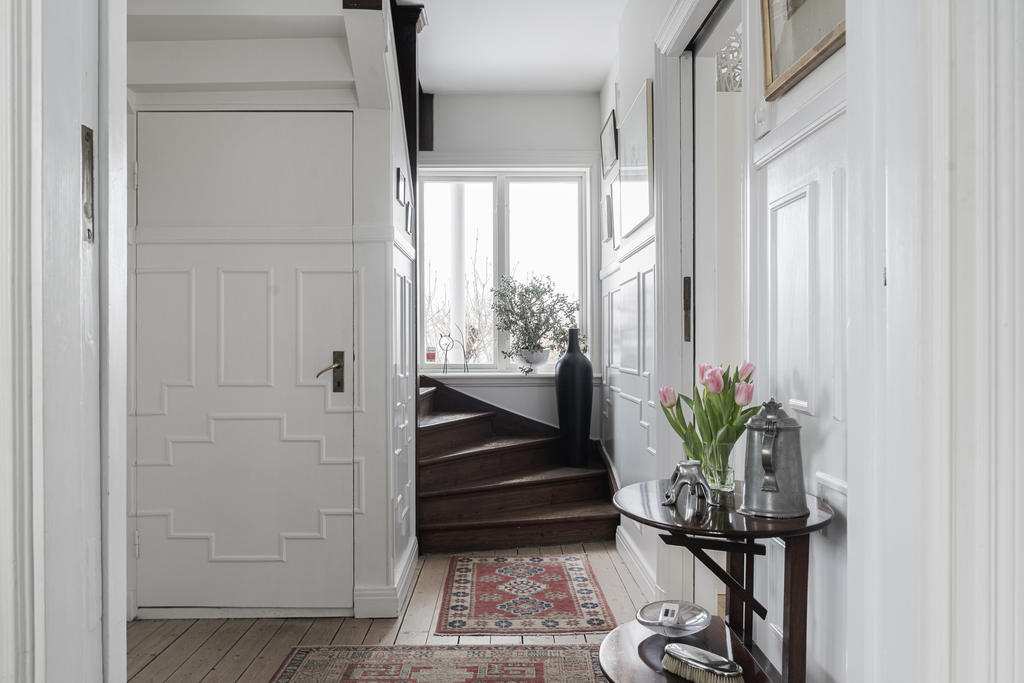 Även den fina trappan som är original tar oss upp till övre plan.  Bakom dörren till väster finns trappan till källarplanet. 