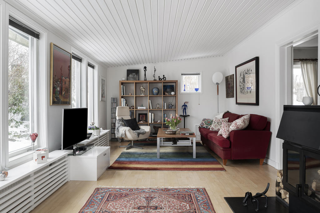 Stort vardagsrum som har plats för både soffa och matsalsbord.