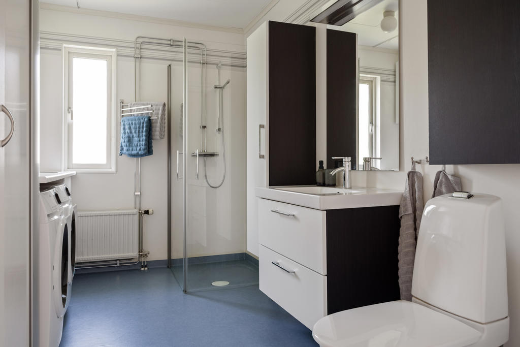 Badrum med dusch och plats för den som sköter tvätten