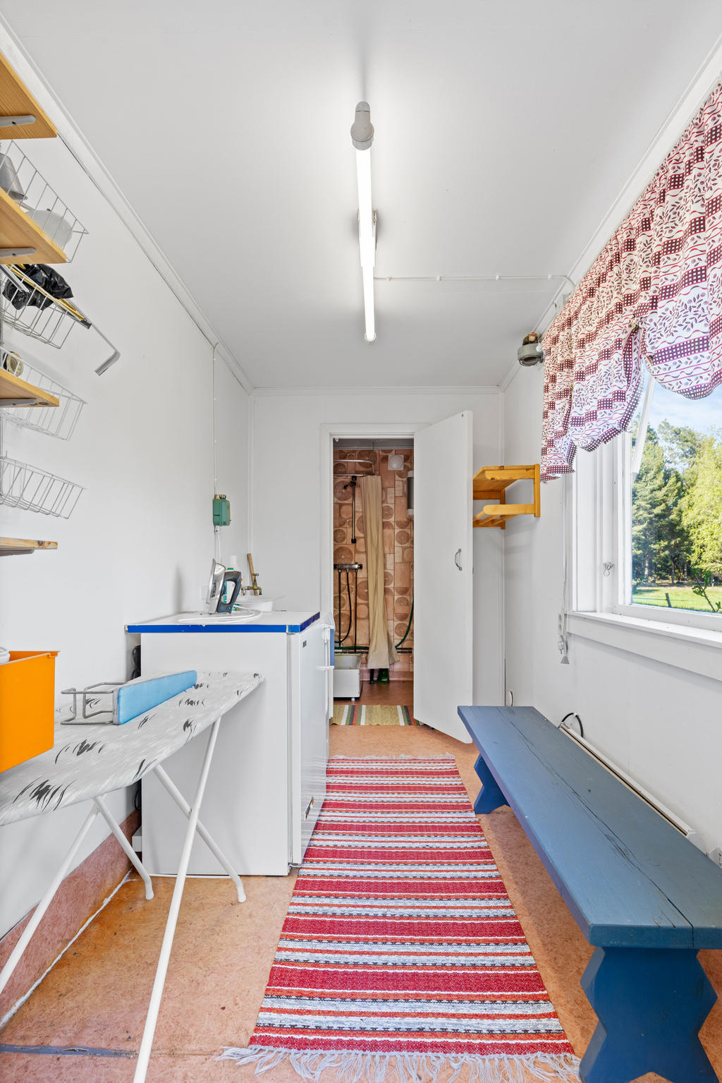 Tvättstuga i garagebyggnad. Innanför finns dusch och toalett. 