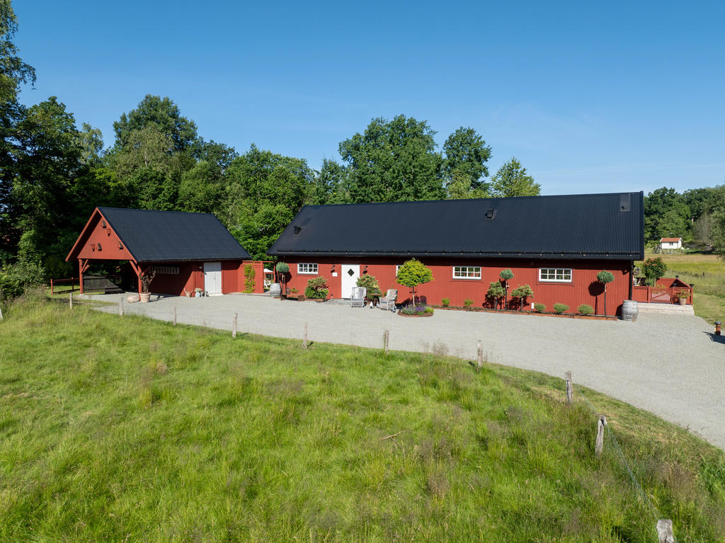Framsidan av huset erbjuder en carport med stort förråd samt gott om parkeringsplatser