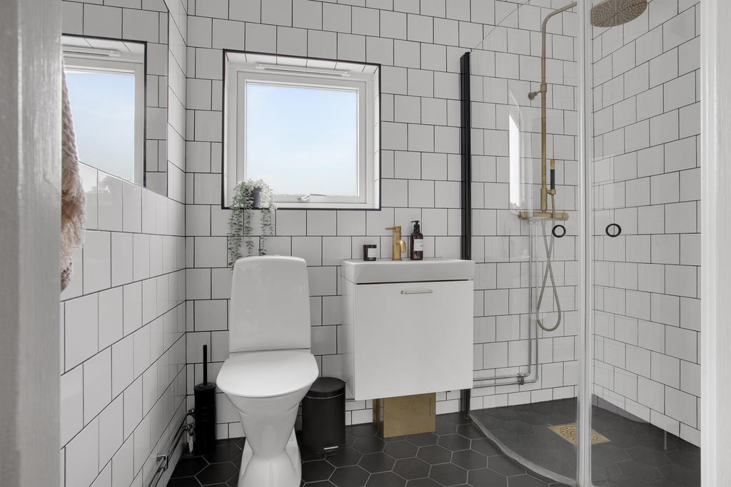 Fint badrum med fin detalj med det sexkantiga klinkern på golvet 