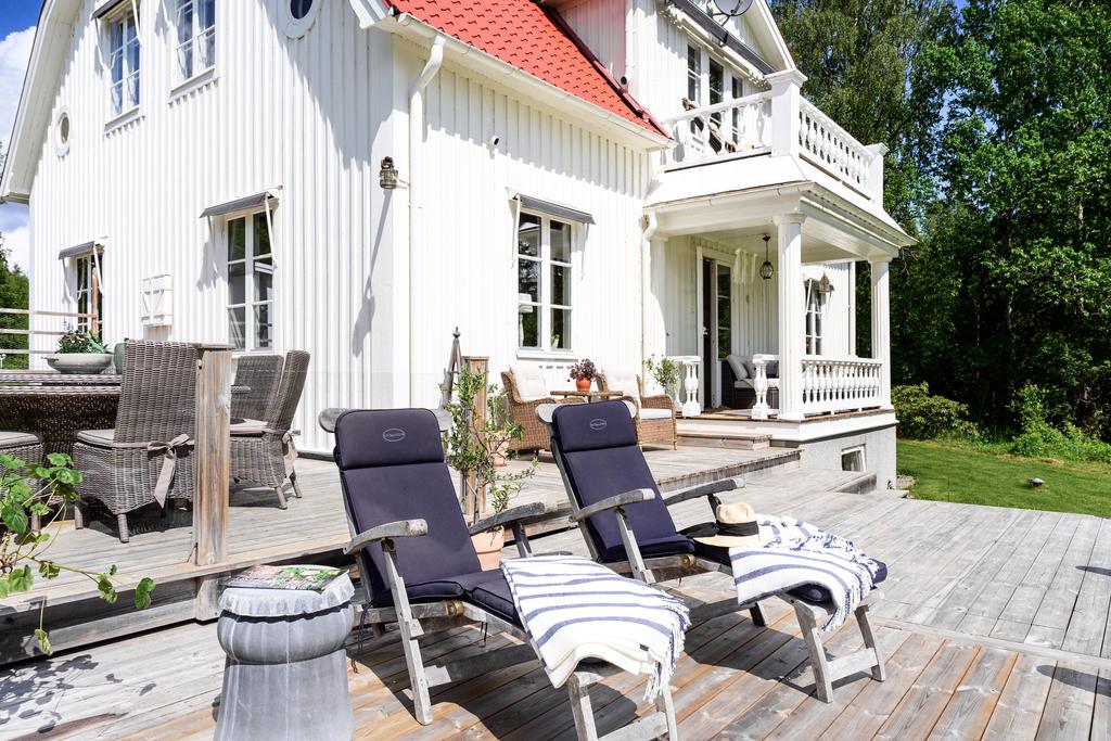 Altanen vetter mot sjön och den trevliga trädgården med grönskande äppelträd