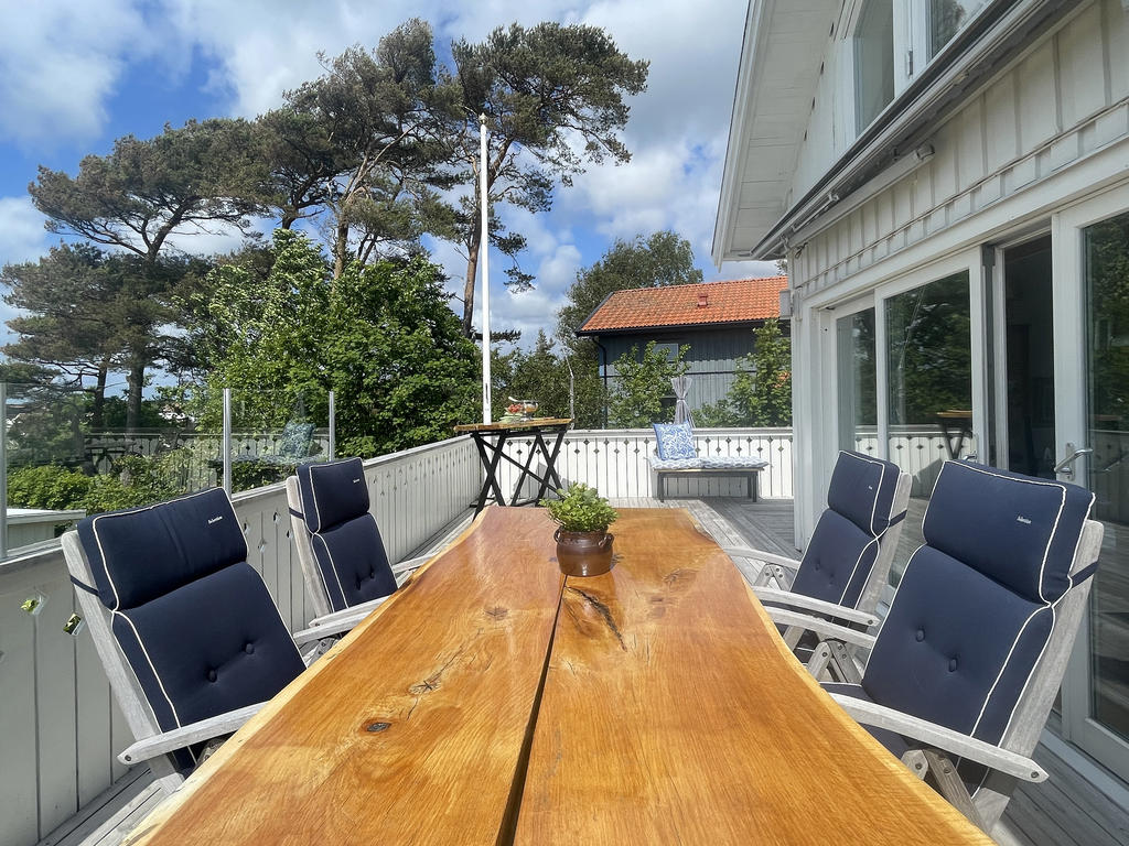 Terrassen utanför vardagsrum och kök. Vid matplatsen på terrassen finns ett läckert vindskydd i glas.