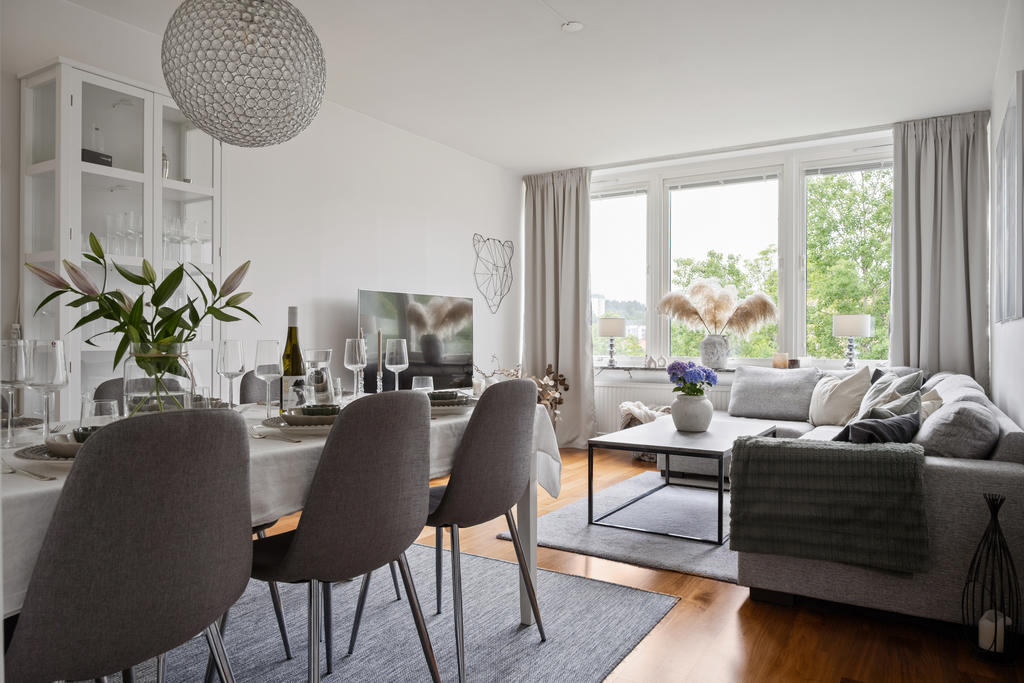 Rymligt vardagsrum med högt i tak och plats för både soffgrupp och matbord