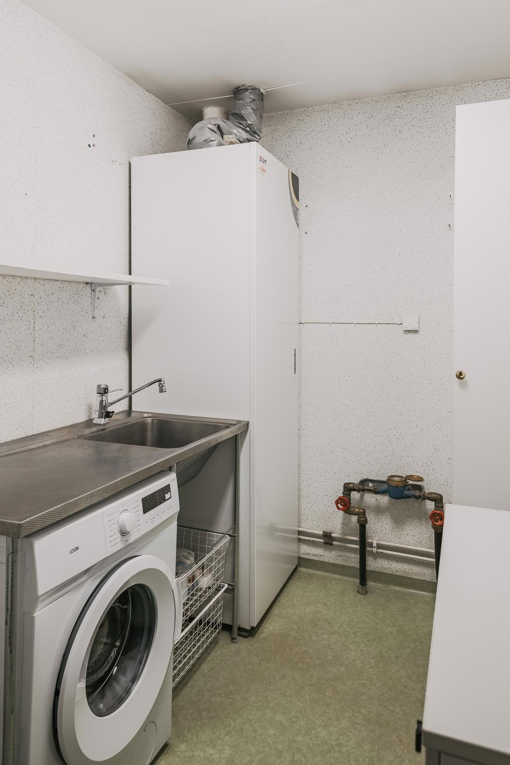 Praktisk tvättstuga med tvättmaskin och grovkök