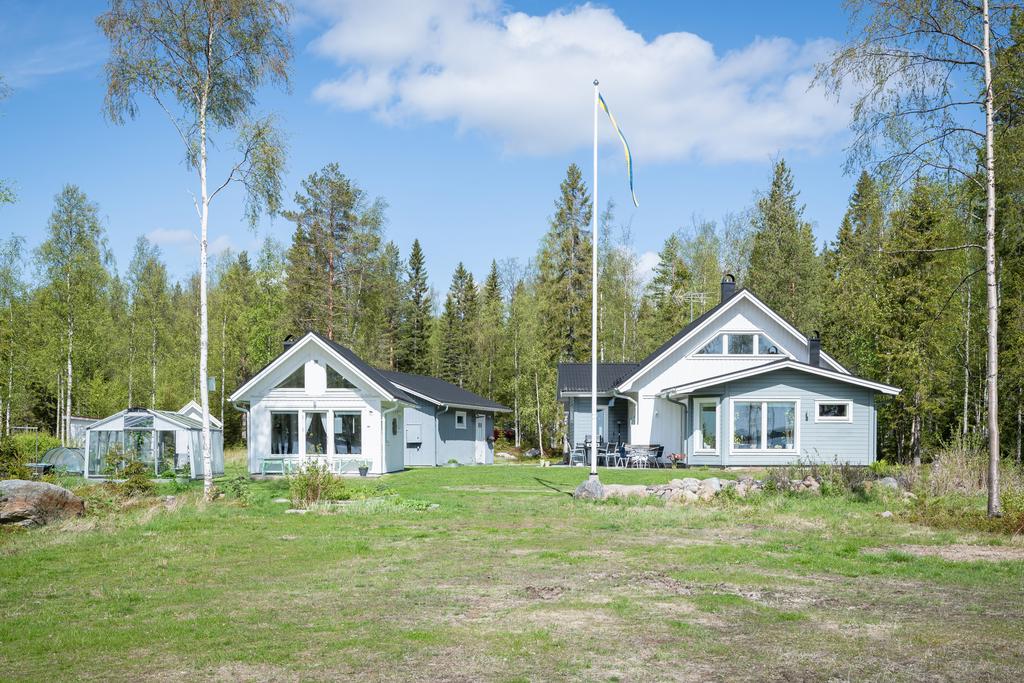 Villan och gästhus. Skymtar även dubbelgarage och växthus.