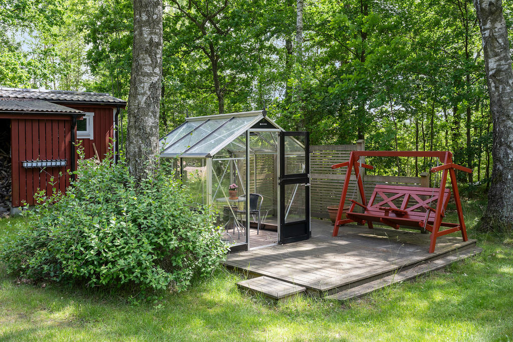 Tralldäck med platsbyggt växthus och hammock för lata dagar