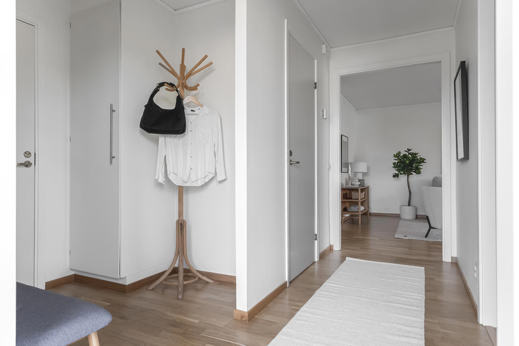 Här möts du av en ljus och trevlig hall med både avhängnings- och förvaringsyta.