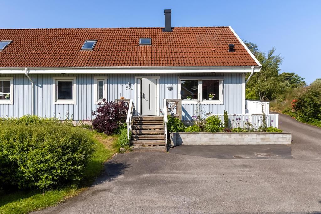 Entrésidan med morgonsol och plats för att parkera två bilar