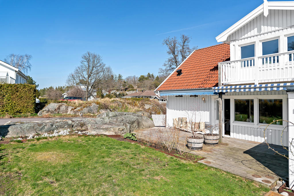 Altan och liten, lättskött gräsmatta (AI-bild - fasaden skall målas vit under våren!)